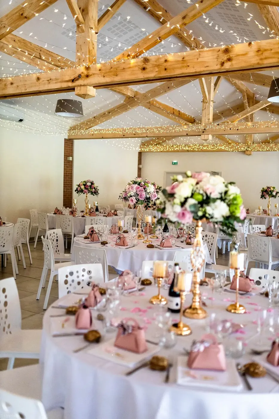 Salle de réception des Lauriers de la Bastide dressée pour un dîner de mariage, charpente apparente et briquettes rouges