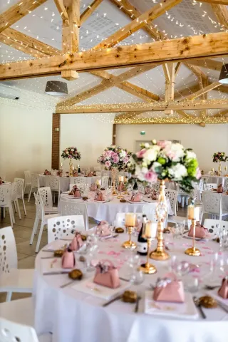 Salle de réception des Lauriers de la Bastide dressée pour un dîner de mariage, charpente apparente et briquettes rouges